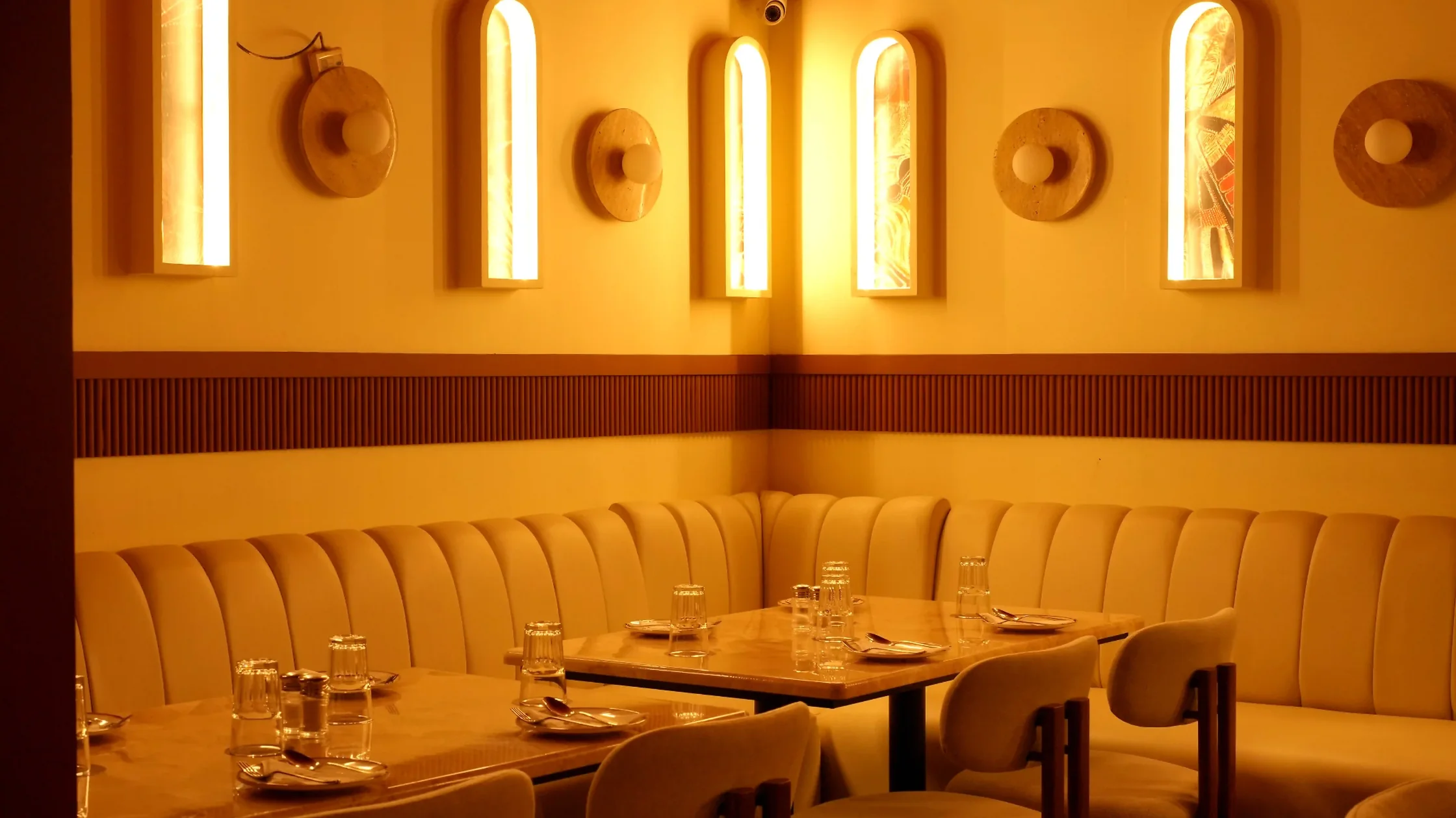 Hotel restaurant interior with warm lighting, comfortable seating, and neatly arranged dining tables in Mysore.